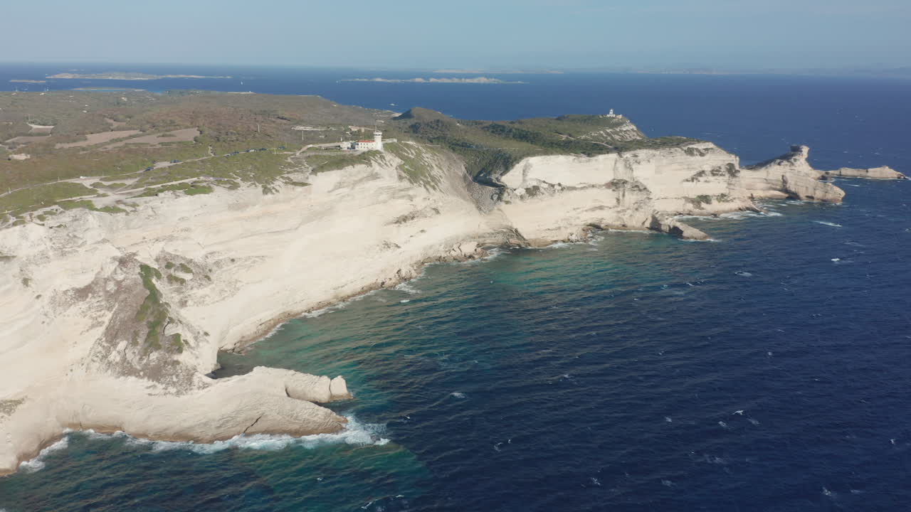 Bonifacio, Corsica aerial drone shot cliffs lighthouse at sunset rugged coastline limestone the turquoise Mediterranean Sea iconic French island landscape