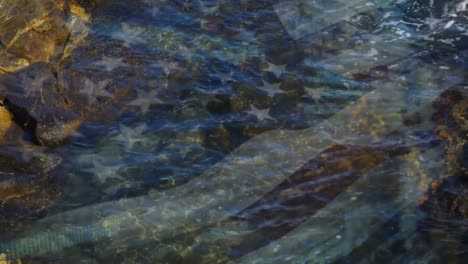 animation of flag of united states of america blowing over sea in a rockpool