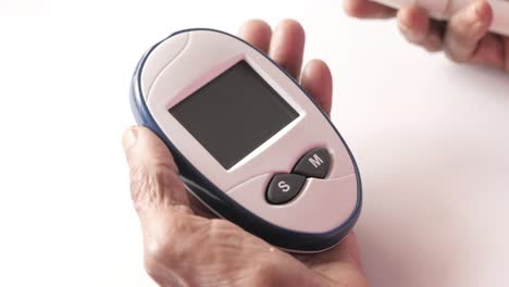 person using a blood glucose meter