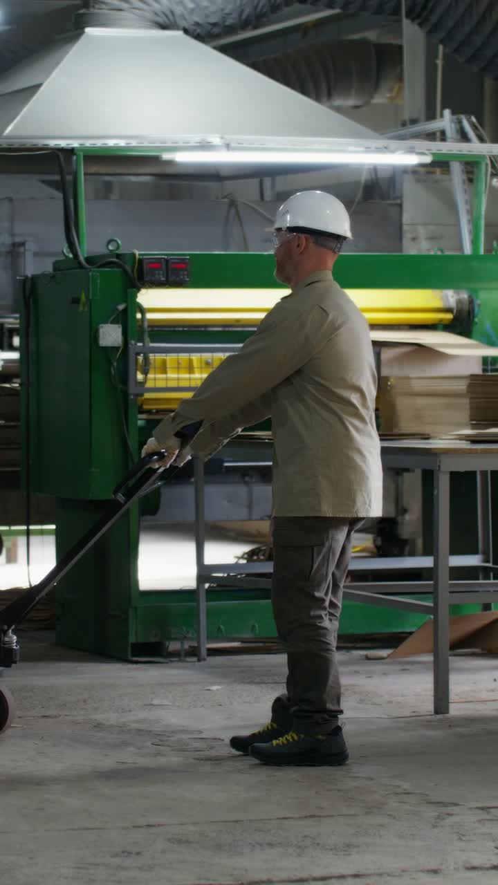 Worker operating machinery in a wood processing factory