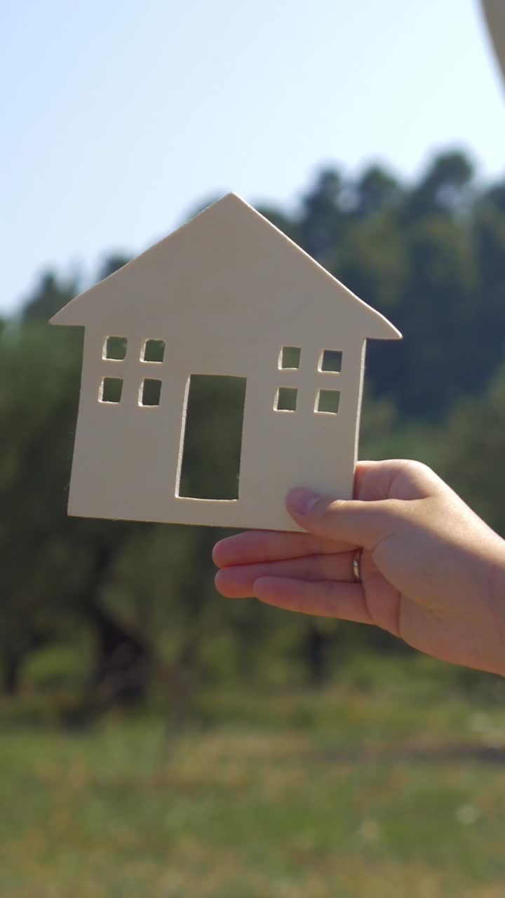 Hand holding a house cutout