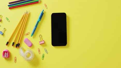 video de composición de diversas herramientas de oficina y teléfono inteligente con espacio de copia sobre fondo amarillo