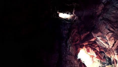 a look inside a dark cave with sunlight shining through the entrance