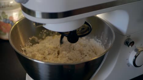 mixing the gluten free flour with milk and yeast with the help of a kitchen assistent