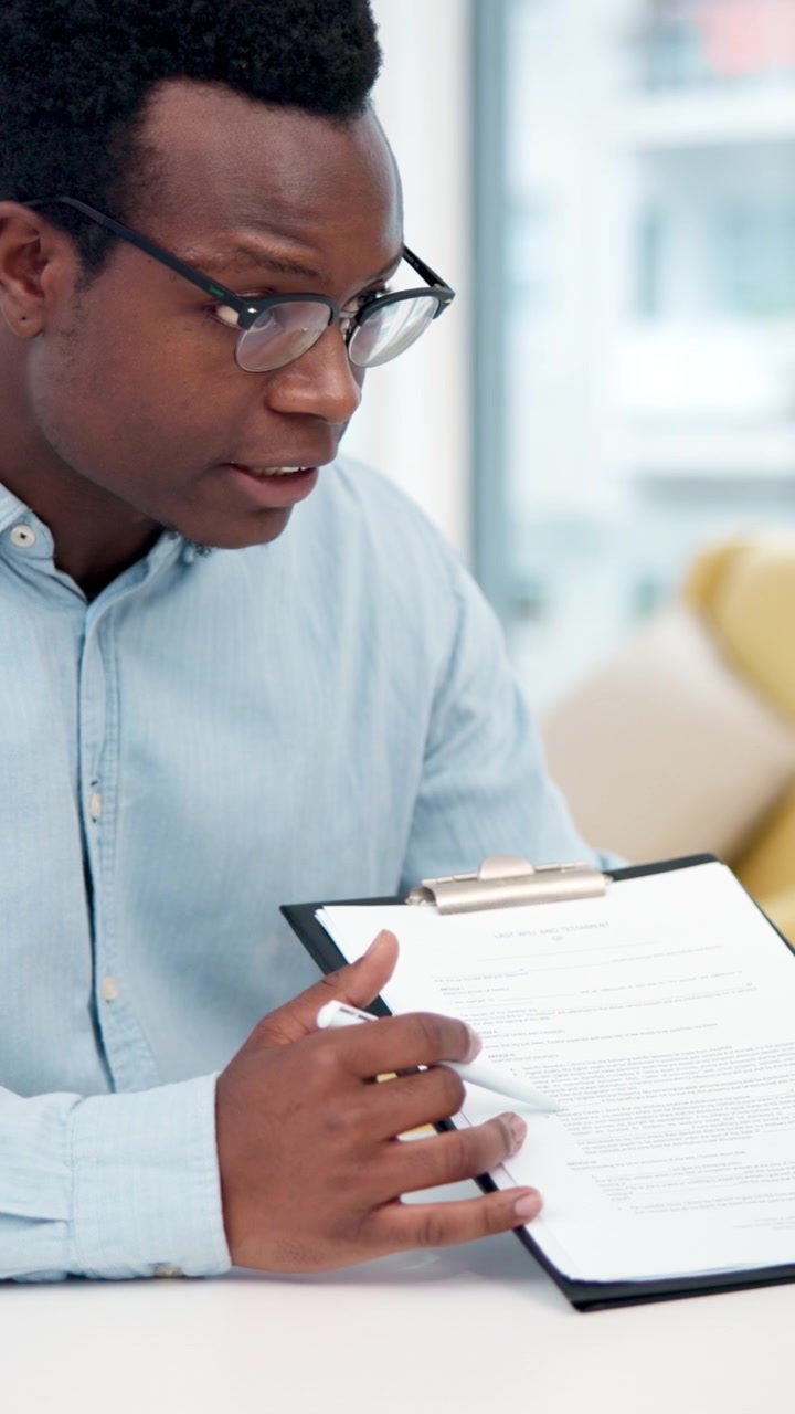 Professional Man Reviewing Legal Document on Clipboard in Office