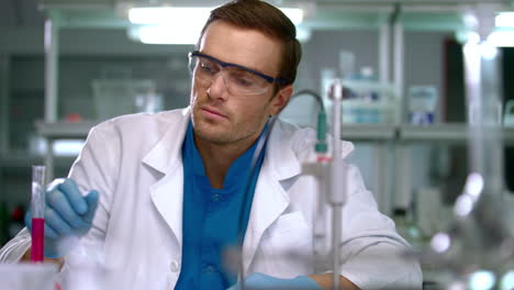 scientist checking test tube with pink liquid. laboratory researcher