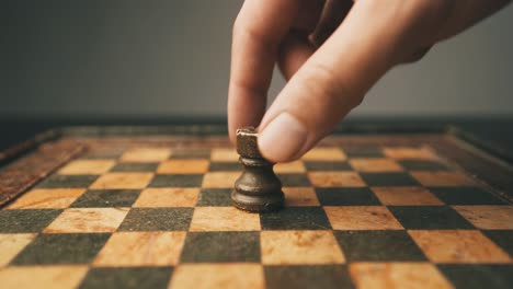 Male-hand-gently-placing-rook-chess-piece-on-game-board