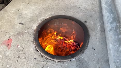 slow motion view landscape shot of scenic clay old local turkish traditional arabic oven burn wooden stick in a hot tube ground oven to make saudi flat bread by persian woman in a rural forest rasht