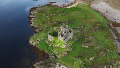 A drone shot of Castle, Tioram a ruined castle that sits on the tidal island Eilean, Tioram in Loch, Moidart, Lochaber, Highland, Scotland