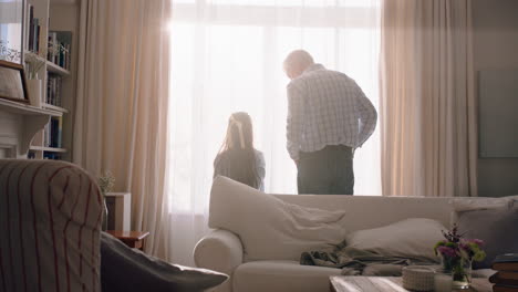 grandfather and child opening curtains curiously looking out window little girl enjoying beautiful new day with grandpa 4k footage