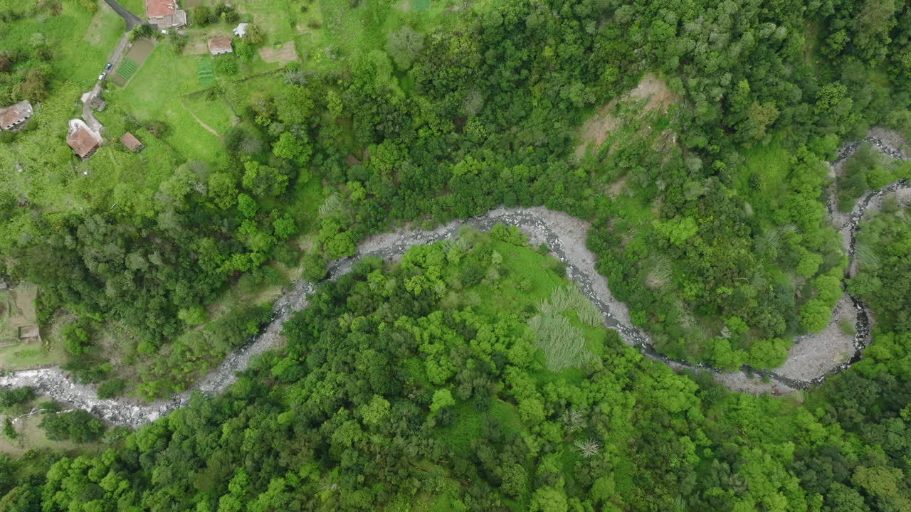 la vista aérea muestra cómo el barranco corre a través de un verde paisaje montañoso.