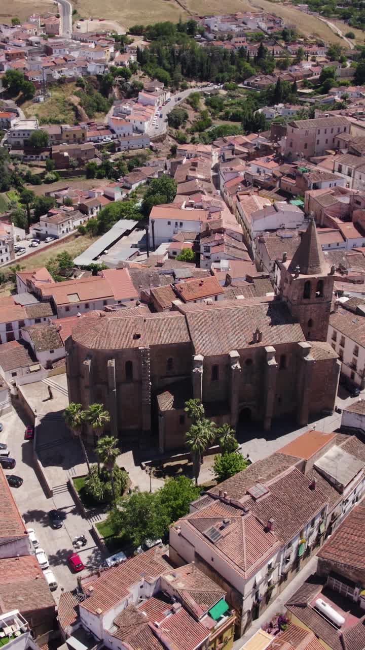 Toma de establecimiento aérea vertical con dolly circular alrededor de la Iglesia de Santiago el Mayor en Cáceres, España, enmarcada por el casco antiguo medieval.
