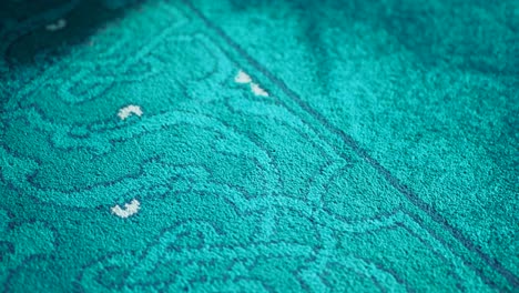 close up of a teal carpet with a patterned design