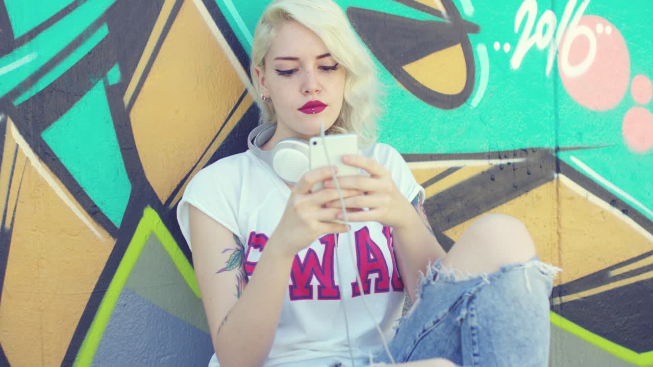 mujer hipster navegando su móvil para la música