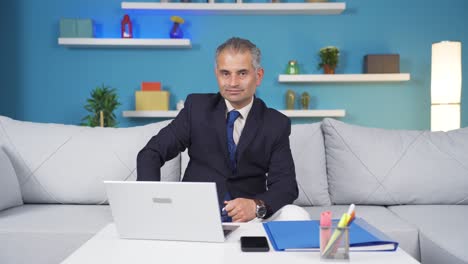 el trabajador de oficina en casa sonríe a la cámara.