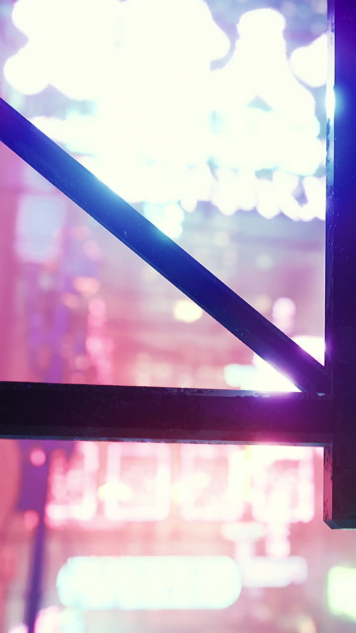 Letreiros de néon coloridos brilham através de uma estrutura de metal à noite numa cidade movimentada.