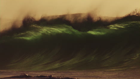 slow motion of powerful offshore waves at golden hour in the pacific ocean, glistening water and sunrise mist rising
