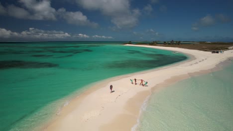 aerial happy family vacation, parents with two child holding hands on white sand beach cayo de agua