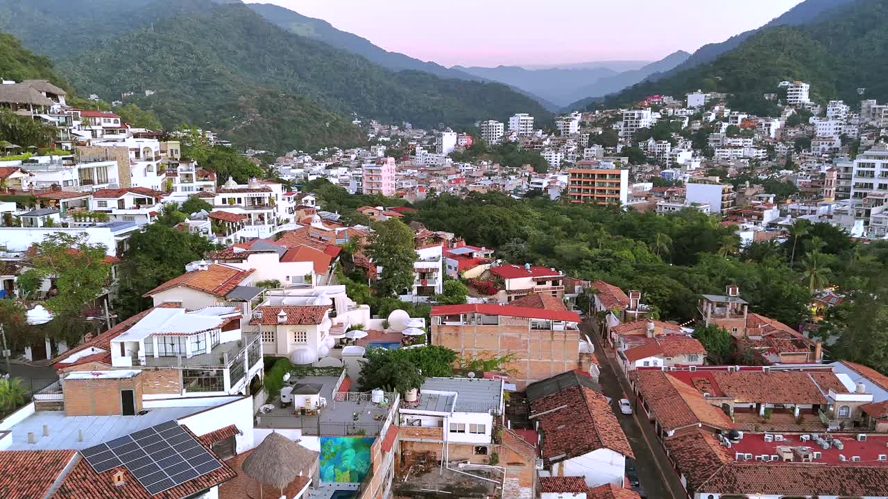 Drone 4K che panoramica a destra su una lussureggiante valle di montagna a Puerto Vallarta, rivelando la città, la vegetazione tropicale e le montagne circostanti