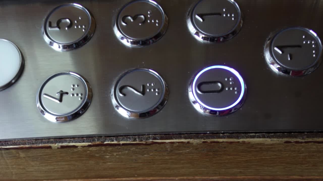 vista vertical de los botones de un viejo ascensor mientras el ascensor baja al piso inferior