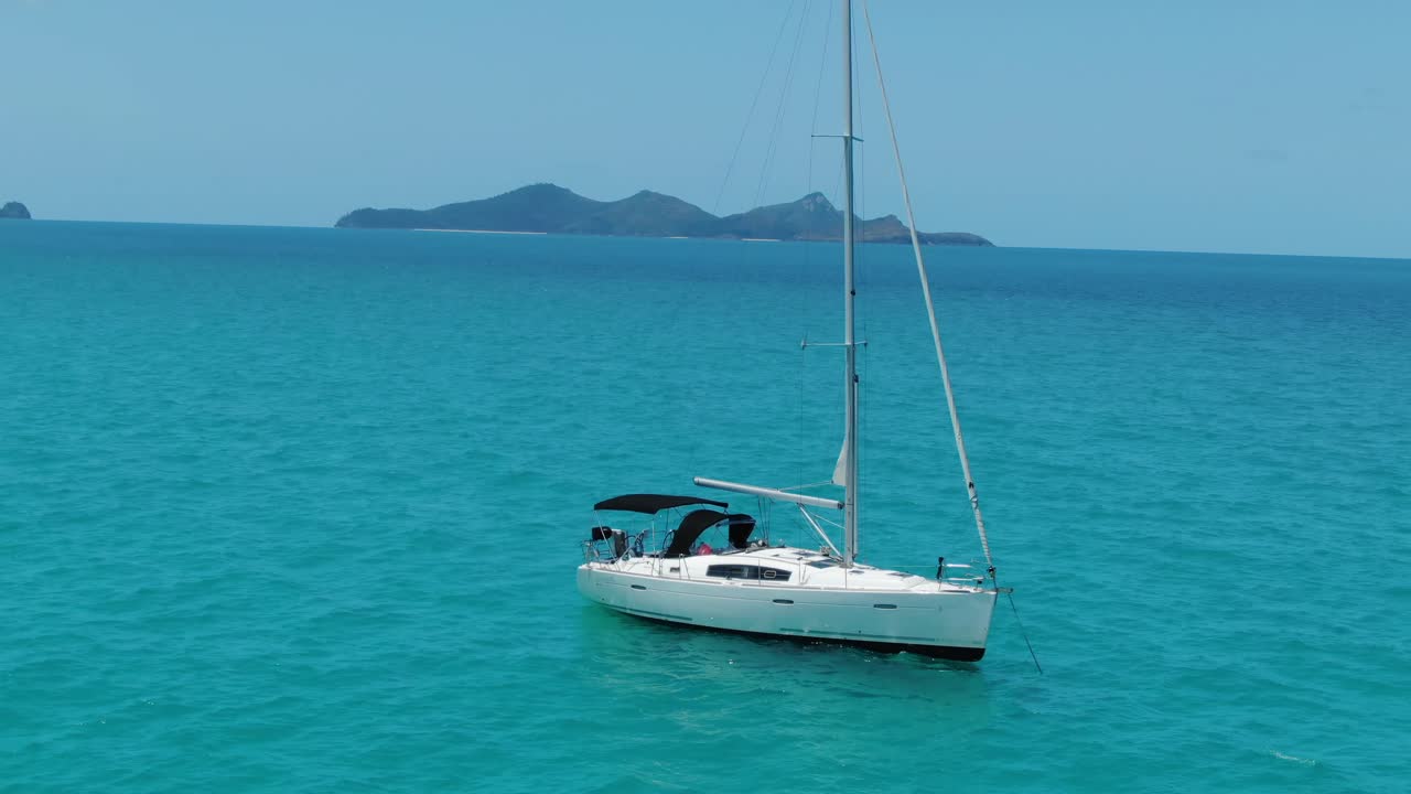 Drone Orbits a White Sail Boat with the Whitsunday Islands in the Background, QLD Australia