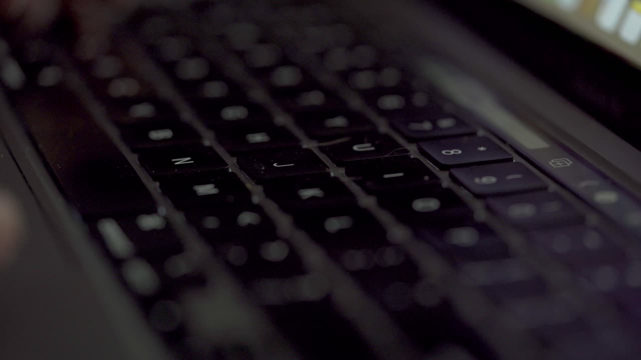 Close Up Shot Of Hands Typing On The Keyboard Of An Apple MacBook Pro Laptop.