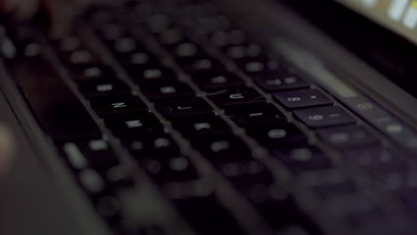 close up shot of hands typing on the keyboard of an apple macbook pro laptop.