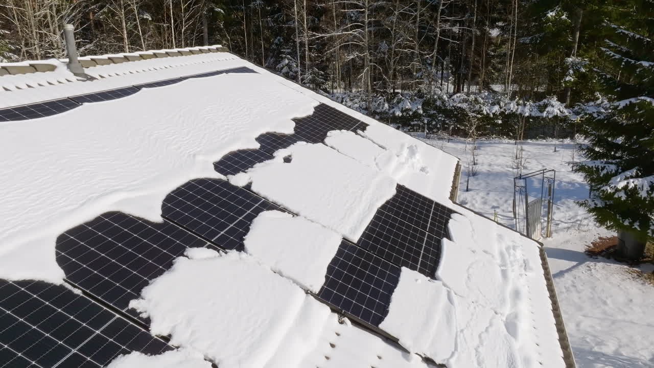 Drone flying backwards over photovoltaic cells on a house roof, sunny winter day