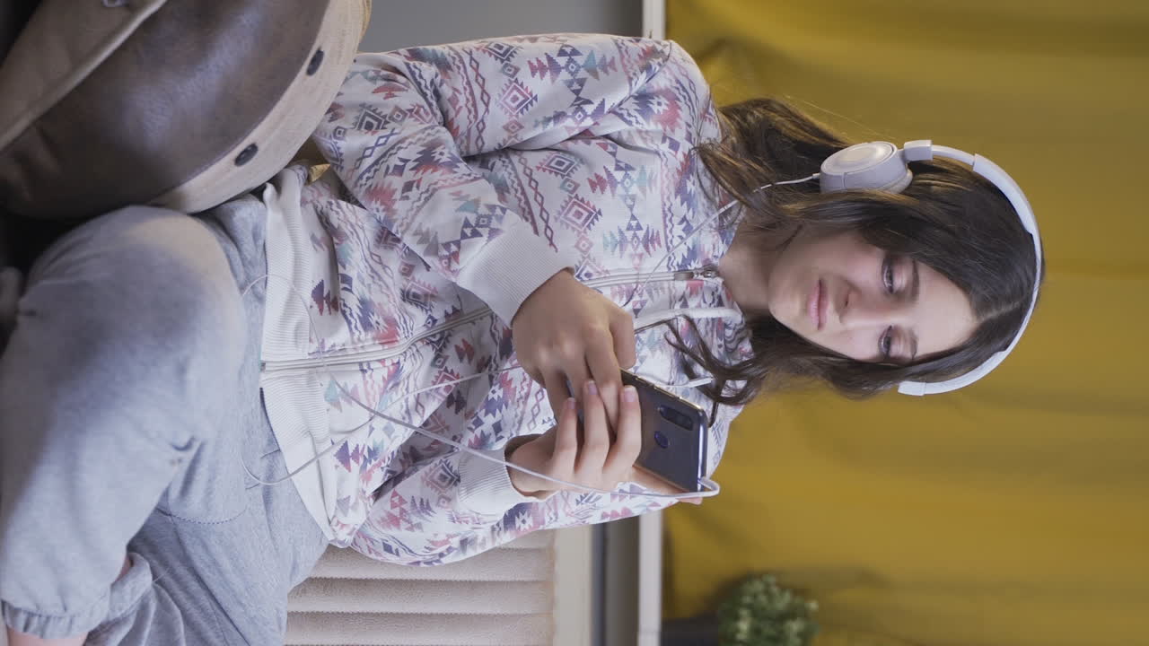 el video vertical de la joven que envía mensajes de texto por teléfono en casa por la noche es decepcionante.