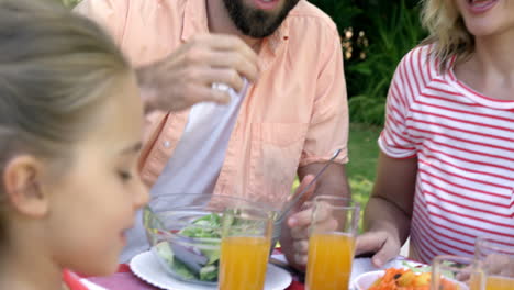 retrato de una familia feliz comiendo en el jardín
