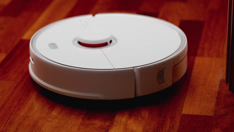 robot aspirador inteligente con lidar en el suelo de madera. robot aspirador realiza la limpieza automática del apartamento. 4k cámara lenta 100 fps, prores 422, 10 bits