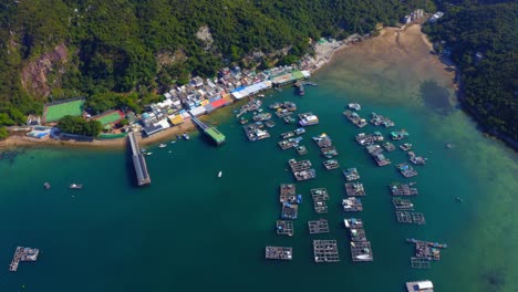 Drone-shot-traveling-forward-and-panning-down-above-a-small-fisher-village-with-a-dock-and-oysters-farm-with-a-beautiful-little-river-delta-with-sand-mud-during-the-day