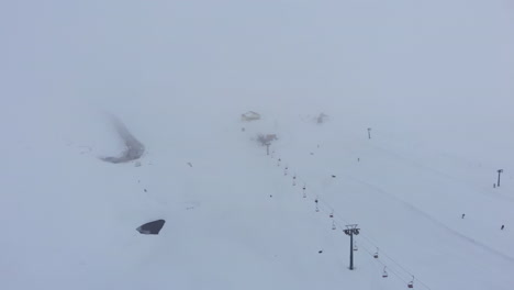 aerial foggy winter snow covered ski resort with very few people moody winter day