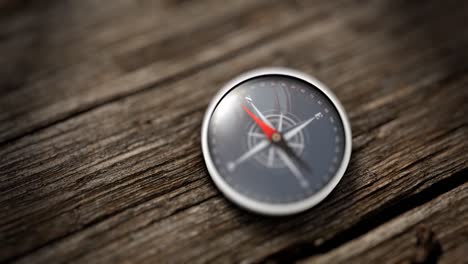 close up compass showing north on a wooden table.