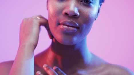 mujer afroamericana con cabello oscuro corto en luz azul y rosa, cámara lenta