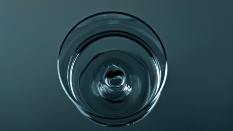 water droplet falling cup top view. pure liquid waving rippling in transparent