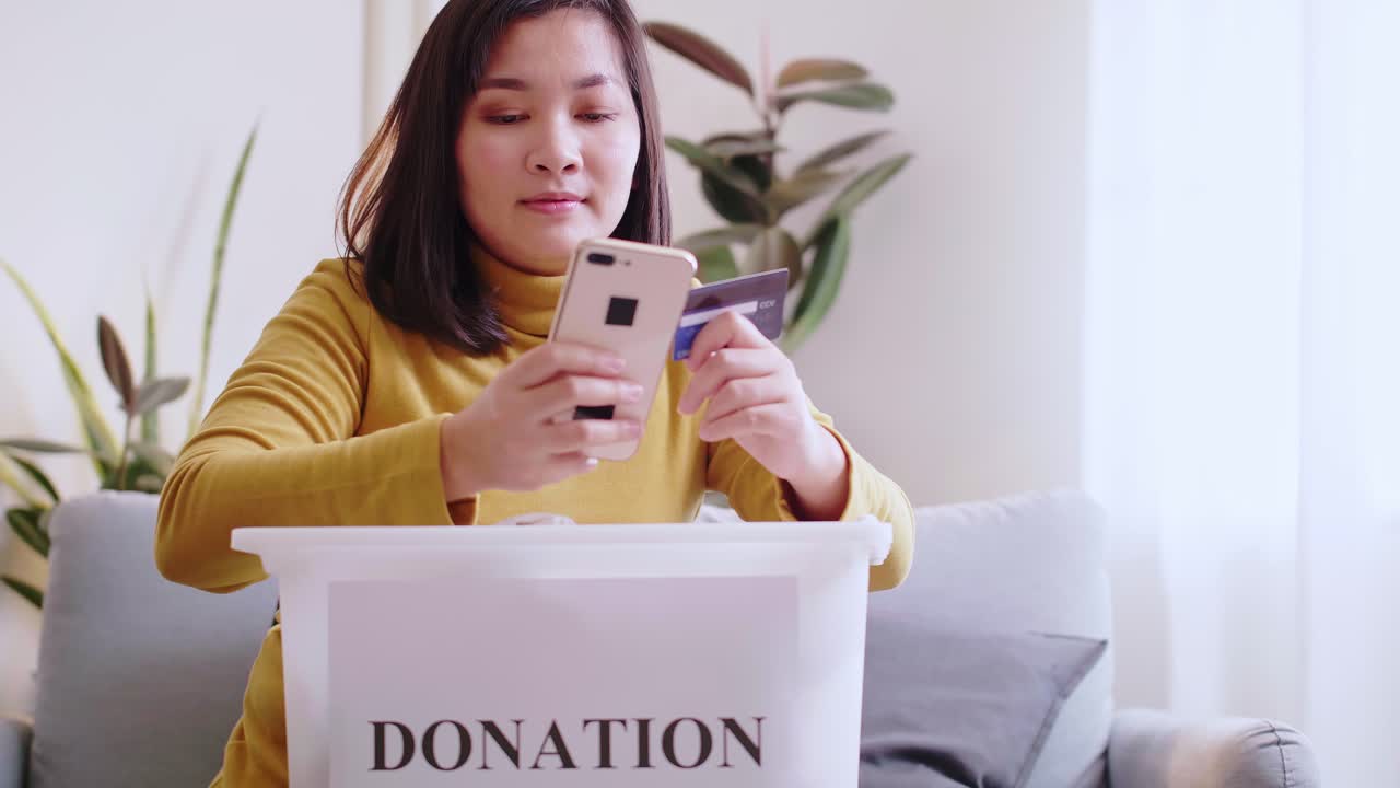 Asian women smile happy are reserving delivery clothing donations to forwarding box