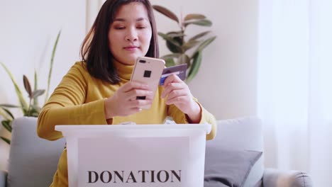 asian women smile happy are reserving delivery clothing donations to forwarding box