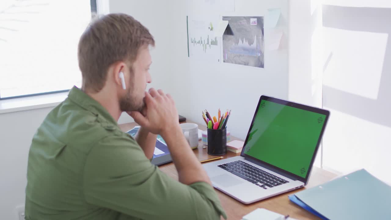 hombre caucásico sentado en un escritorio trabajando en casa