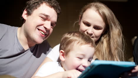 Parents-watching-son-playing-game-on-touchpad