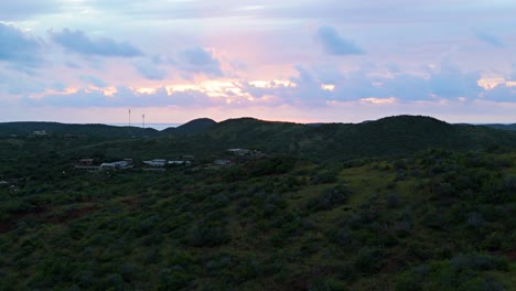 Sunset-glow-breaks-between-clouds-on-Caribbean-sea-with-Curacao-nature-hiking-hills-on-leeward-coast