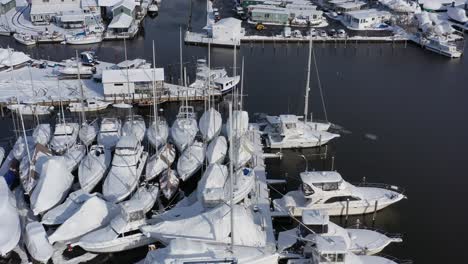 A-drone-view-over-a-marina-in-Bay-Shore,-NY-in-the-morning-after-a-recent-snowfall