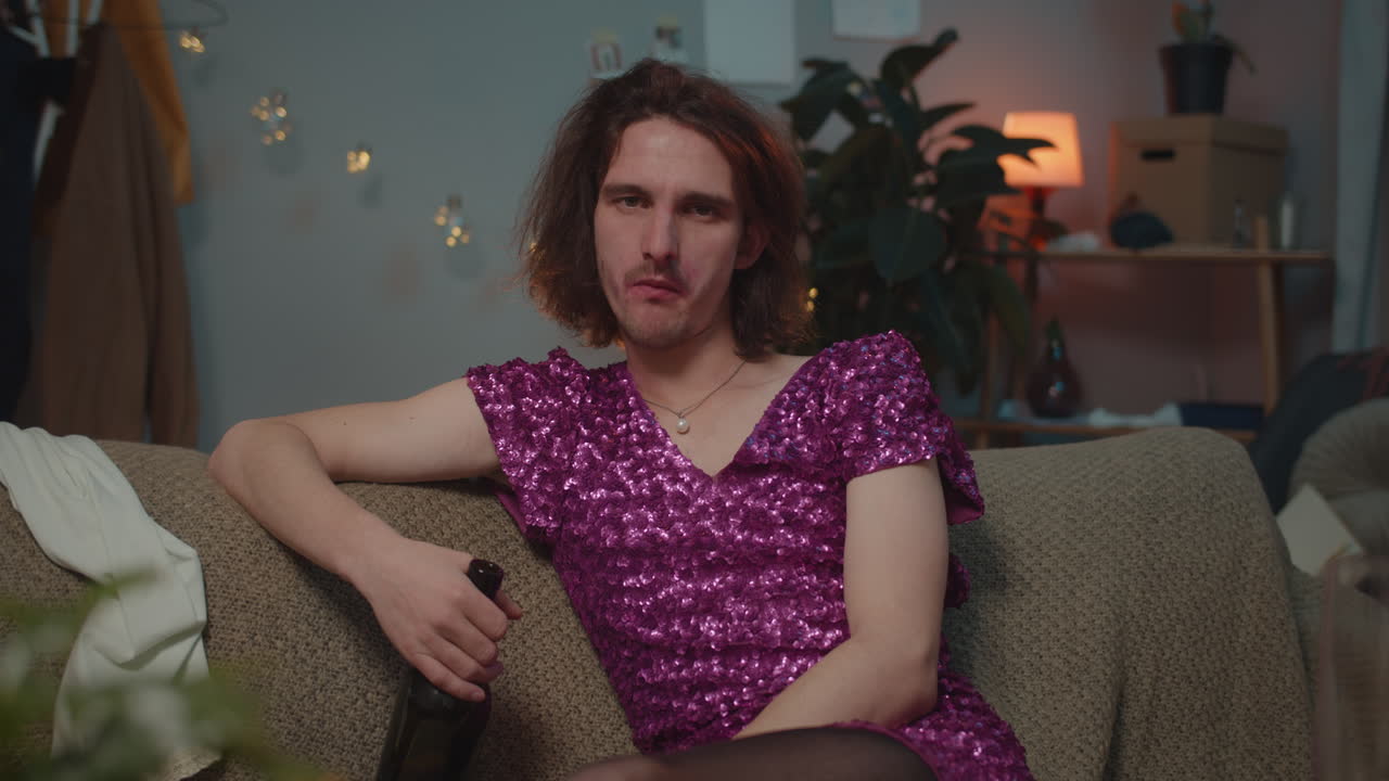 A man in a dress sitting on a couch