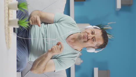 video vertical de un anciano feliz escuchando música con auriculares.