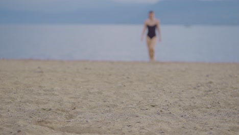 Verschwommene-Sicht-Auf-Ein-Attraktives-Mädchen,-Das-Auf-Dem-Sand-Sitzt