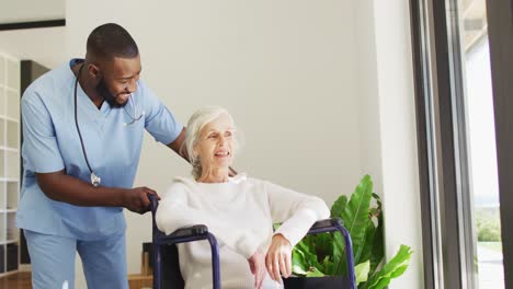 video of happy african american male doctor taking care of caucasian senior woman