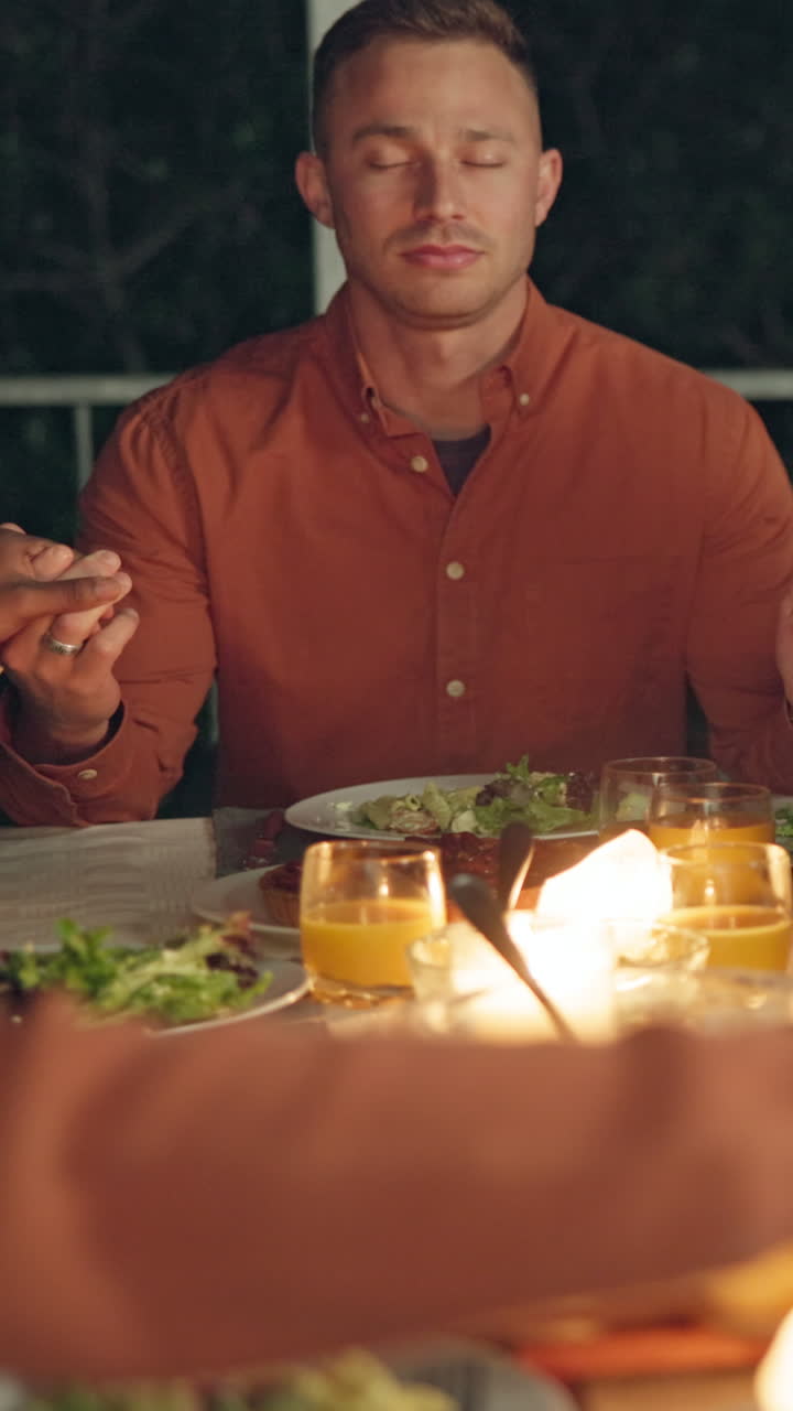 Uomo con gli occhi chiusi che prega prima di una cena all'aperto.