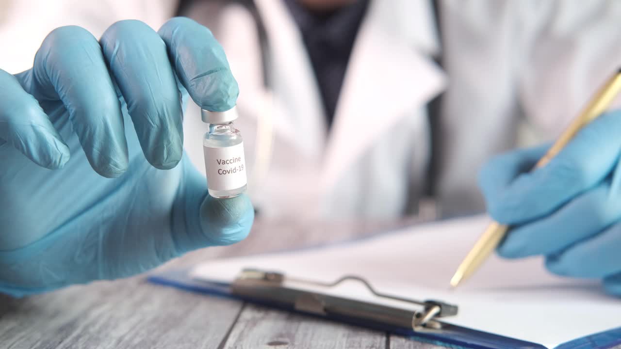 médico que sostiene el vial de la vacuna contra la covid-19