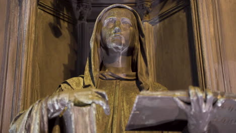 statue of a hooded figure with a book,raised arm,alcove,at night,prague,czechia