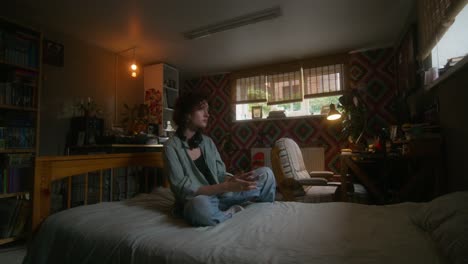 young woman in bedroom using smartphone